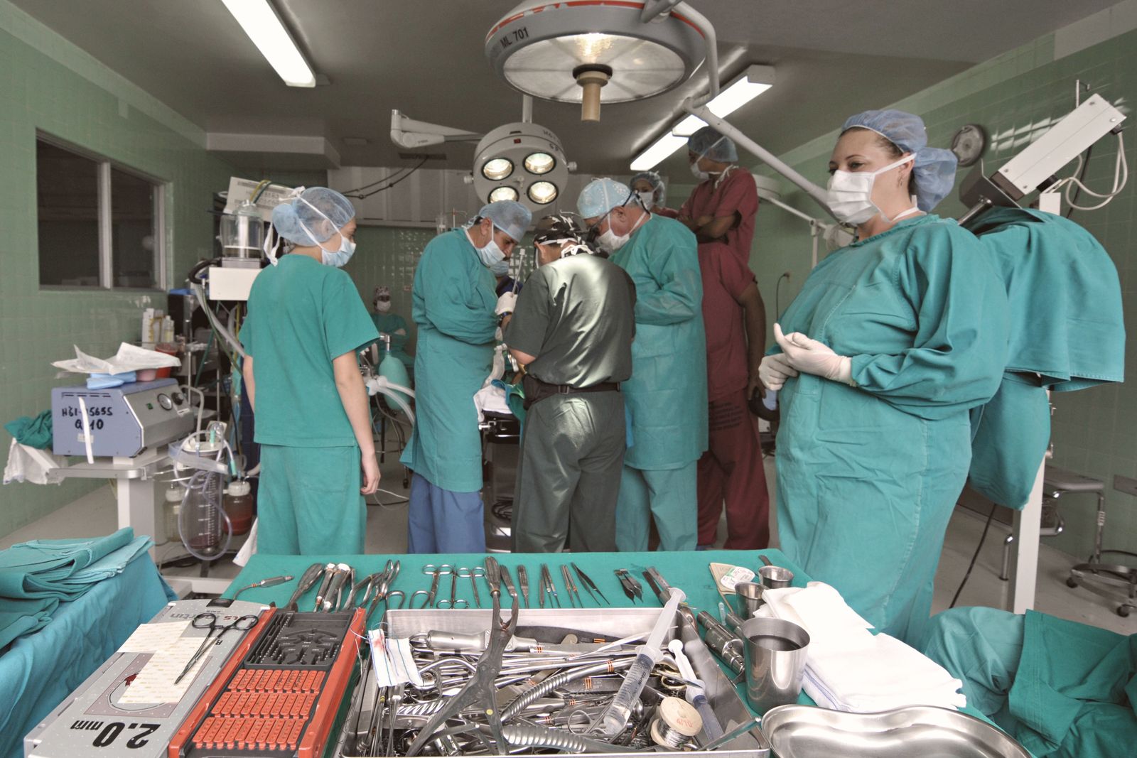 A surgical team in scrubs and masks working together in an operating room
